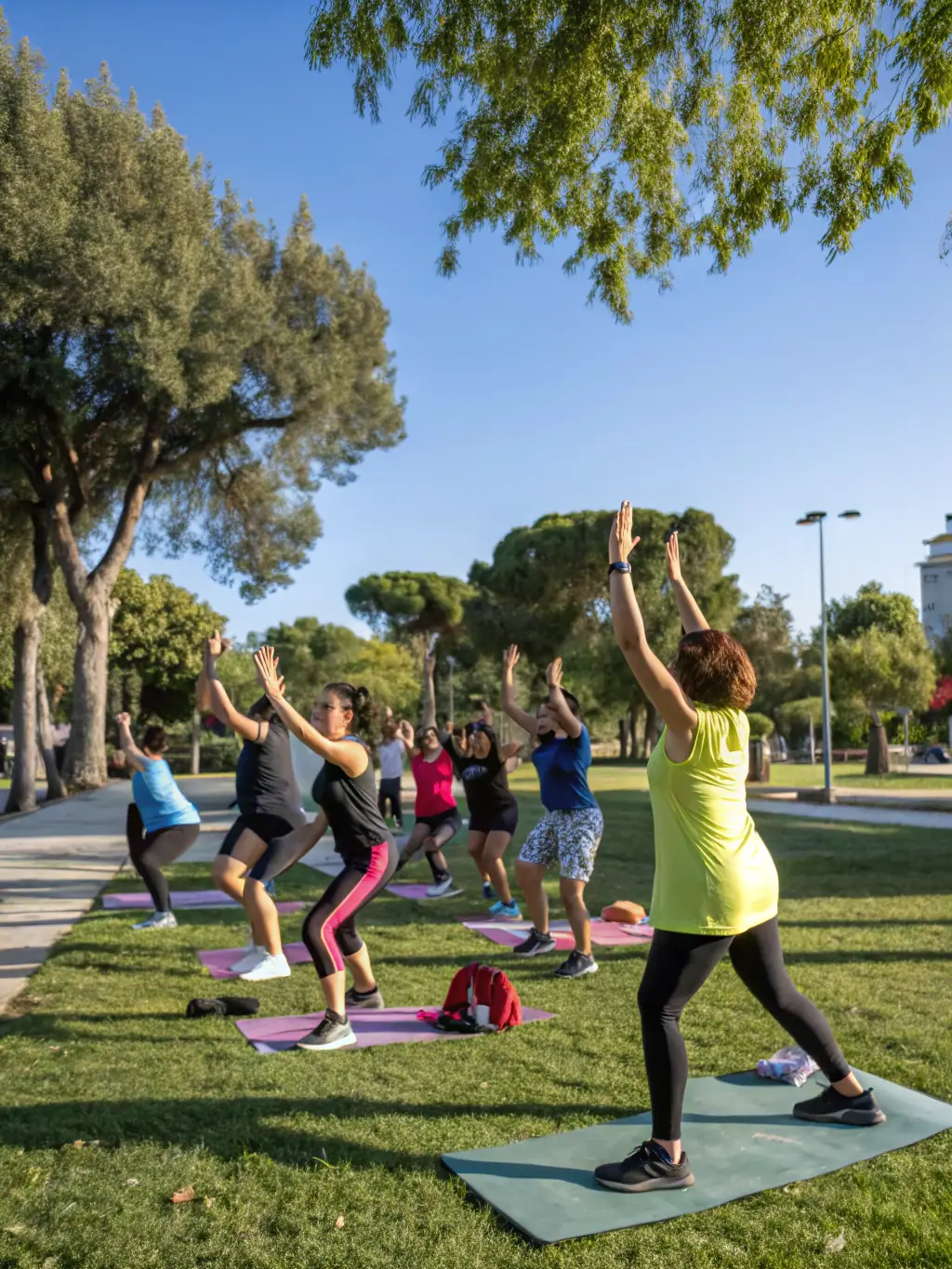 A diverse group of individuals participating in a community fitness class in a park, led by an instructor, showcasing LINE UP 14's commitment to health and well-being.
